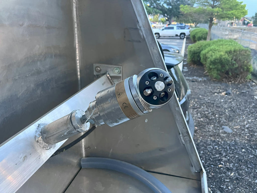 Trash bin cleaning spray equipment used by Spotless Bin Co